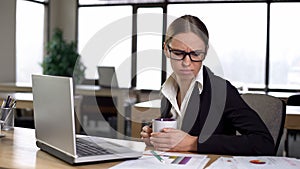 Woman bored working at computer, exhausted and unmotivated, coffee break