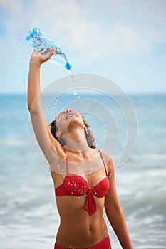 Woman with bottle is staying near water on sea photo
