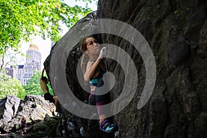 Woman bouldering on a rock, Central Park, New York