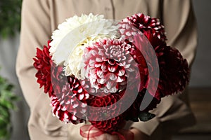 Woman with bouquet of beautiful dahlia flowers indoors, closeup