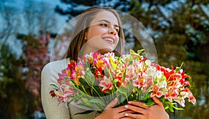 Woman with bouquet of flowers. Spring holiday concept. Girl, flowers, spring, outdoors. Spring concept. Beautiful woman