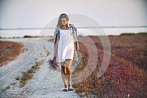 Woman with a bouquet of flowers walking on the road