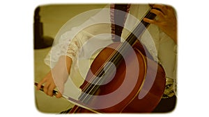 A woman with a bow drives the strings of a double bass. 8mm retro style film.