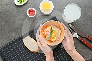 Woman with bowl of fresh tasty shrimp and grits