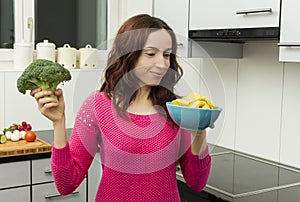 Woman with a bowl of potato chips and broccoli