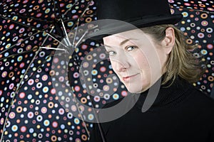 Woman in a bowler hat with umbrella