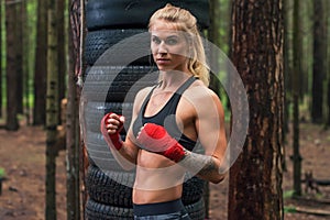 Woman boxer professional fighter posing in boxing stance, working out outdoors