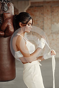 Woman boxer wearing hand wrap in gym. Boxing girl training
