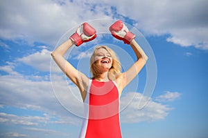 Woman boxing gloves raise hands blue sky background. Girl boxing gloves symbol struggle for female rights and liberties