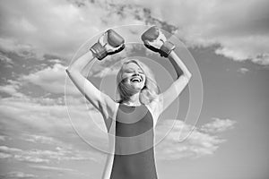 Woman boxing gloves raise hands blue sky background. Girl boxing gloves symbol struggle for female rights and liberties