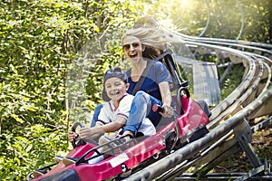 Woman and boy enjoying a summer fun roller coaster ride photo