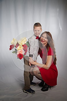 Woman with a boy with flower. Mom with son on a white background in mothers Day. Family portrait with mother and boy