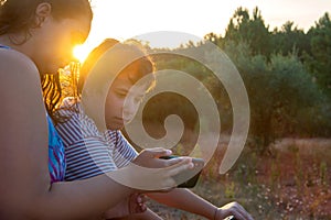 Woman and boy looking at a phone outdoors