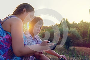 Woman and boy looking at a phone outdoors