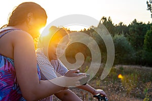 Woman and boy looking at a phone outdoors