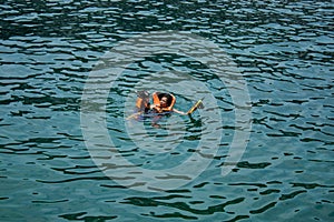 Woman and boy wearing a life jacket, scuba diving in the sea