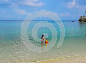 Woman and boy wearing a life jacket, scuba diving in the sea.