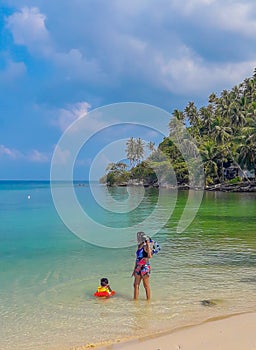 Woman and boy wearing a life jacket, scuba diving in the sea.