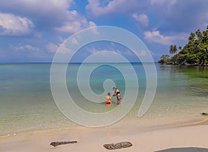 Woman and boy wearing a life jacket, scuba diving in the sea.