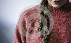 Woman with braid and lipstick wearing a pink warm soft glitter winter sweater