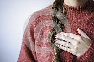 Woman with braid and nail polish wearing a pink warm soft glitter winter sweater