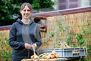 Woman braiding onions in the garden