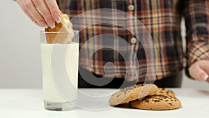 Woman break cookie dipping warm milk snack