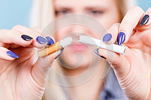 Woman breaking cigarette, getting rid of addiction