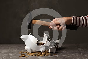 Woman breaking piggy bank with hammer