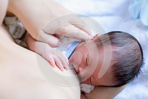 Woman breast feeding her baby on light background. mother holding her newborn child. Mom nursing baby. Woman and new born boy in w