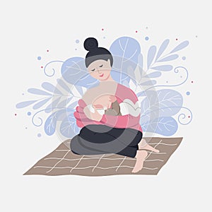 Woman breastfeeding baby while sitting on mat