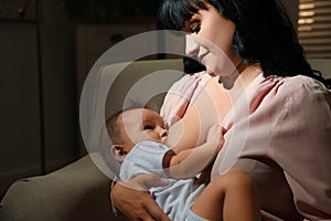 Woman breastfeeding her little baby on sofa