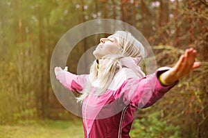 Woman breathes fresh air outdoors in autumn