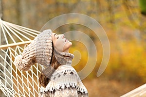 Woman breathing fresh air on hammock in autumn