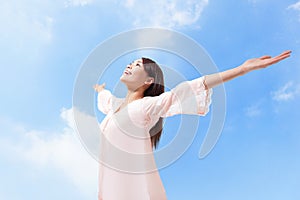 Woman breathing fresh air with raised arms