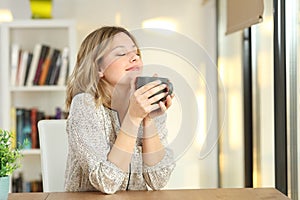 Woman breathing holding a coffee mug at home