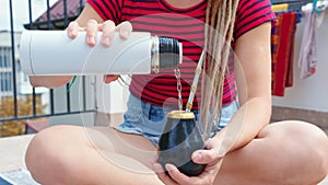 A woman brews Argentine mate tea in calabash