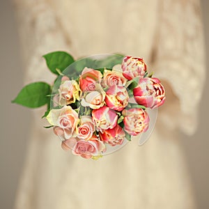 Woman bride hands holding spring flowers tulips and roses, boho wedding dress