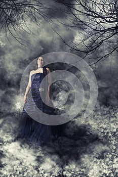 Woman bride with wedding dress in mysterious ghostly dark landscape