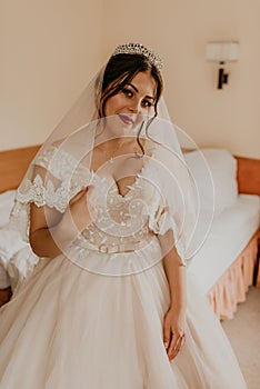 woman bride in white wedding dress with long veil and tiara on head