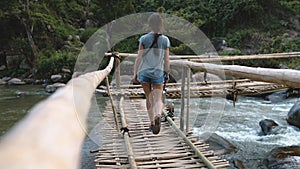 Woman on bridge over fast mountain river thailand