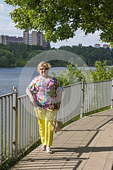 a woman in bright clothes is relaxing in a park in nature.