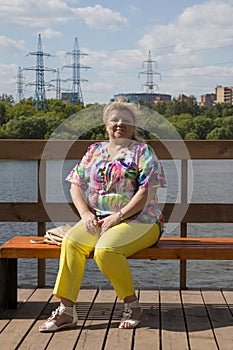 a woman in bright clothes is relaxing in a park in nature.