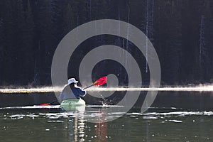 Woman In Bright Kayak On Lake