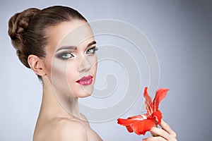 woman with bright makeup and red flower