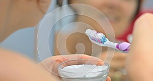 Woman brightening teeth with bicarbonate