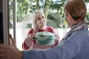 Woman Bringing Meal For Elderly Neighbour photo