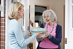 Woman Bringing Meal For Elderly Neighbour photo
