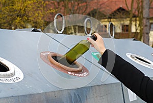 Woman bringing the used glas to the bottle bank
