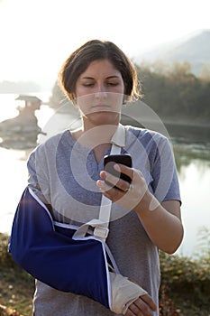Woman with a broken arm and smart phone